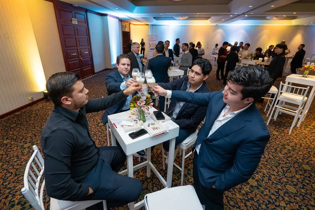 Participantes brindando ao redor de uma mesa alta durante o coquetel.