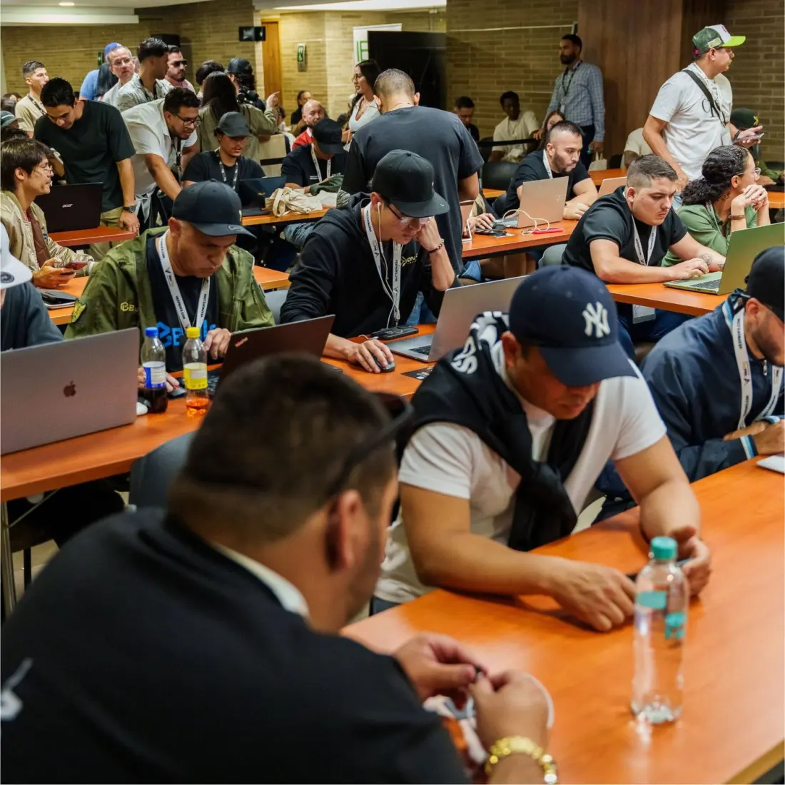 Traders com laptops em mesas longas durante a FX Experts Cup.